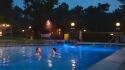 Gasten zwemmen in de avond in het buitenbad
